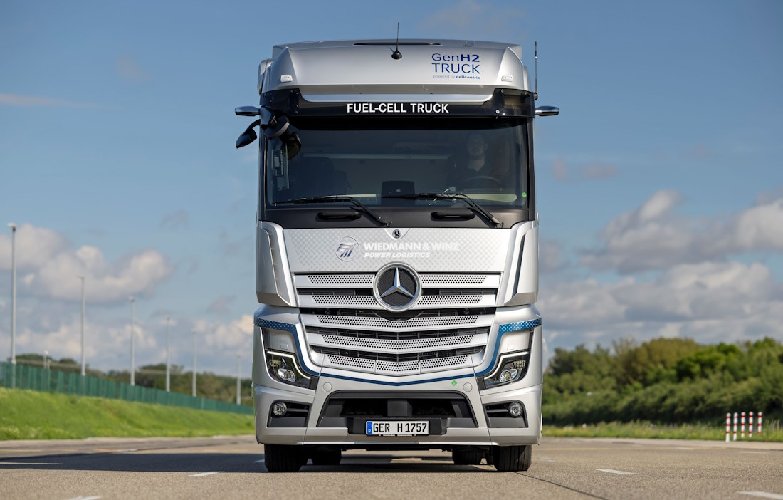 Ein grauer LKW mit einem weißen Container auf dem Container-Chassi