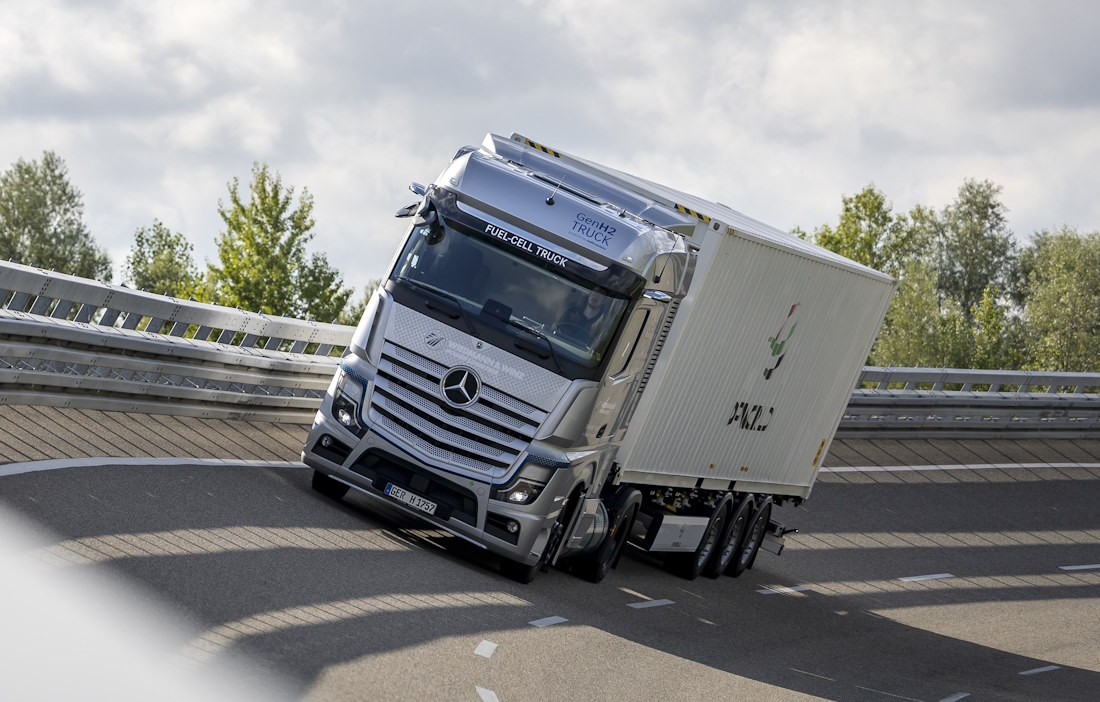 Ein grauer LKW mit einem weißen Container auf dem Container-Chassi